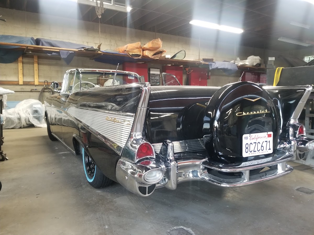 Black '57 Chevy Bel Air rear with continental kit in the shop